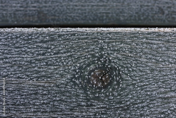 Fototapeta Frozen pattern and snowflakes on wooden planks knot pattern. Color photo for background. 