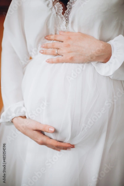 Fototapeta Young beautiful pregnant women holding her belly