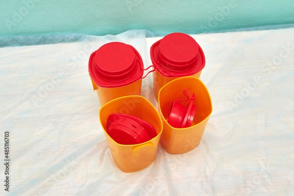 Fototapeta Medical red container for the collection of tests with an open lid on the background of other containers. Concept: passing medical tests.