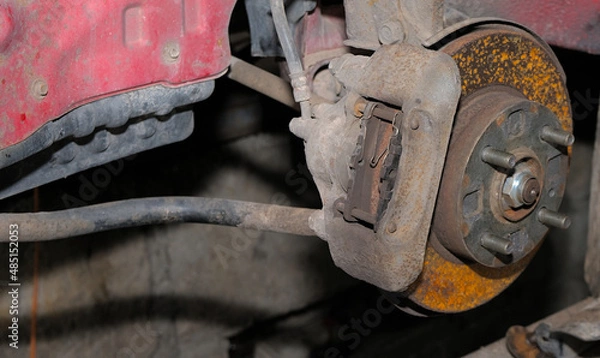 Fototapeta Brake system of a car. Brake disc with traces of oxidation and brake caliper on a car