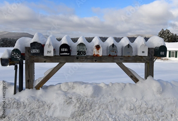 Fototapeta Mailboxes covered with fresh snow along rural road