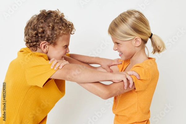 Fototapeta Boy and girl casual wear games fun together posing emotions quarrel unaltered