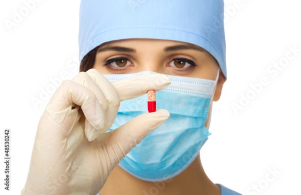 Fototapeta Young doctor holding red pill