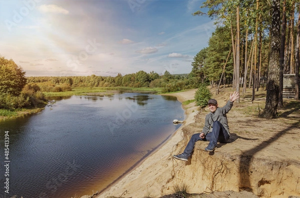 Obraz Guy relaxes in nature near the river.