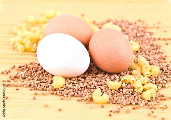 Obraz Three eggs, buckwheat, pasta and spaghetti