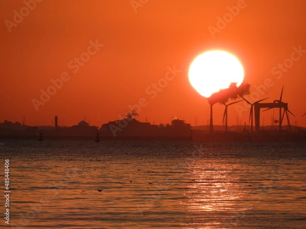 Obraz 太陽と朝焼けに映る工場