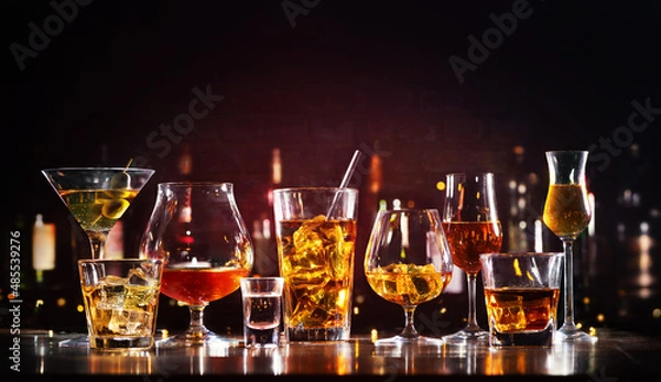 Fototapeta Assortment of hard strong alcoholic drinks and spirits in glasses on bar counter