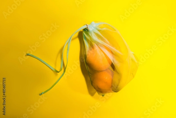 Obraz  Fruits in a disposable bag on a yellow background. High quality photo