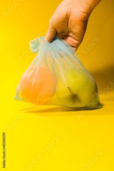 Fototapeta  Fruit lies in a reusable bag for shopping on a yellow background. Vertical photo. High quality photo