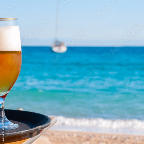 Fototapeta Photo of cold beer glass on the bar table in summer day