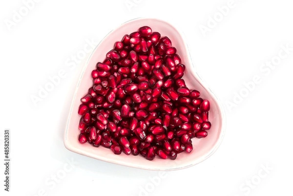 Fototapeta grains garnet in dish on white