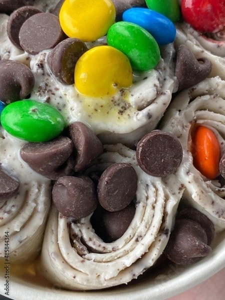 Fototapeta Rolled Ice Cream Topped With Chocolate Chips and Chocolate Candies