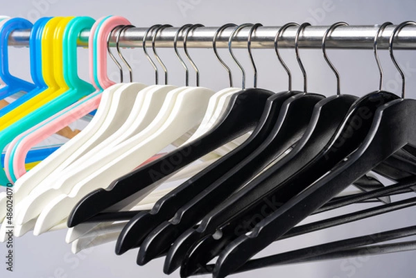 Obraz Metal rack with clothes hangers on grey background