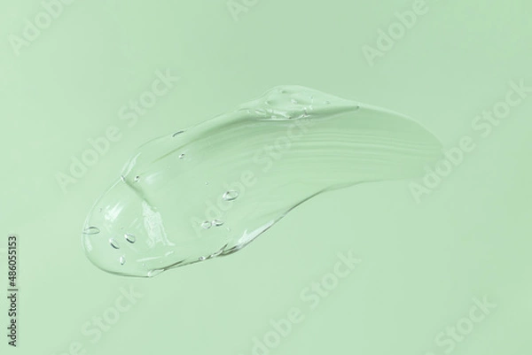 Fototapeta Smear of transparent cosmetic gel on mint background.Copy space for text,mockup concept.