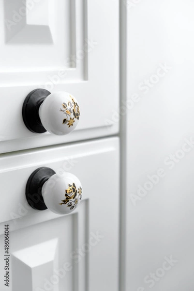 Fototapeta Extremely close-up detail of vintage white cabinet, original ceramic handles, selective focus, copy space