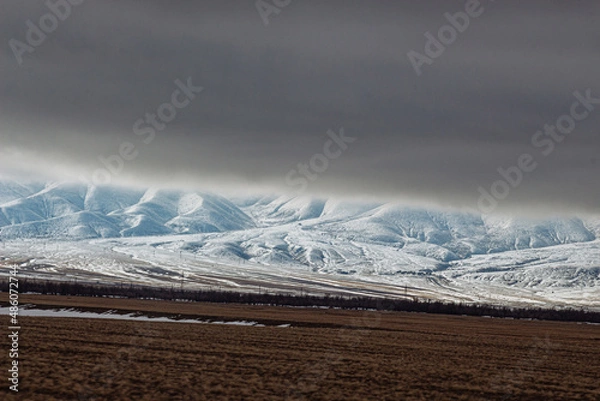 Fototapeta amazing mountains under grey clouds and reflection in mountain lake