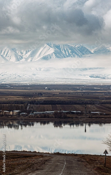 Fototapeta amazing mountains under grey clouds and reflection in mountain lake