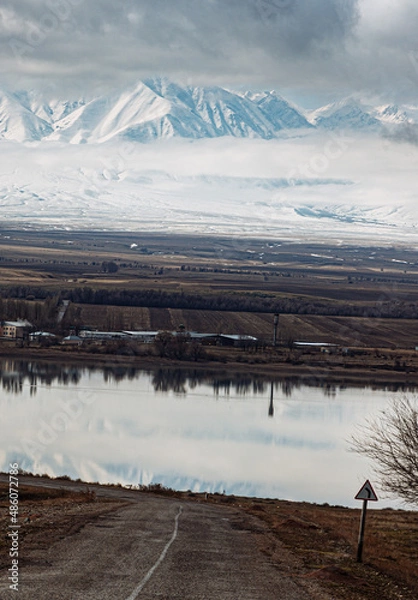 Fototapeta amazing mountains under grey clouds and reflection in mountain lake