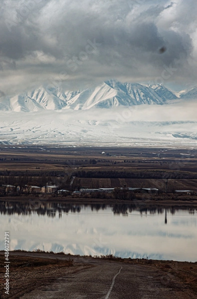 Fototapeta amazing mountains under grey clouds and reflection in mountain lake
