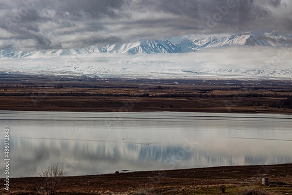 Fototapeta amazing mountains under grey clouds and reflection in mountain lake