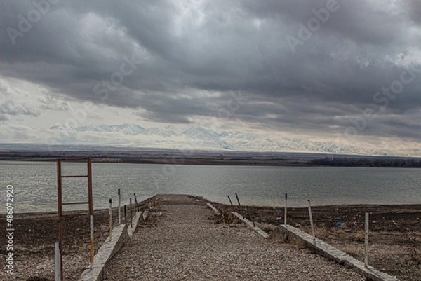 Fototapeta amazing mountains under grey clouds and reflection in mountain lake