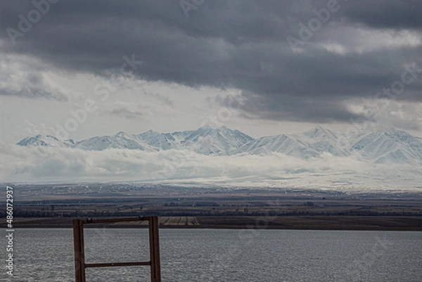 Fototapeta amazing mountains under grey clouds and reflection in mountain lake