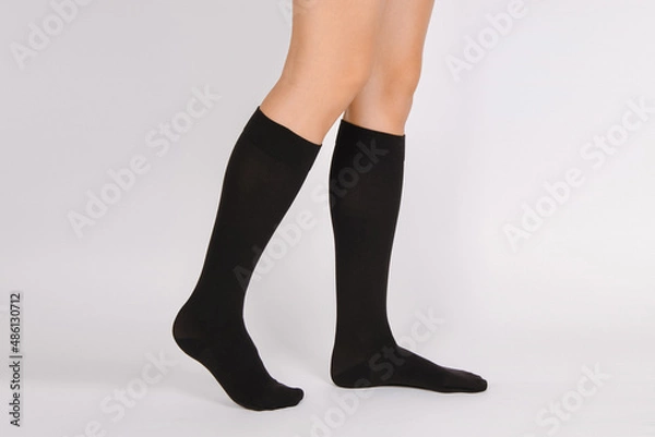 Fototapeta Medical Compression Stockings for varicose veins and venouse therapy. Compression Hosiery. Sock for sports isolated on white background. Black color socks mock up for advertising, branding, design