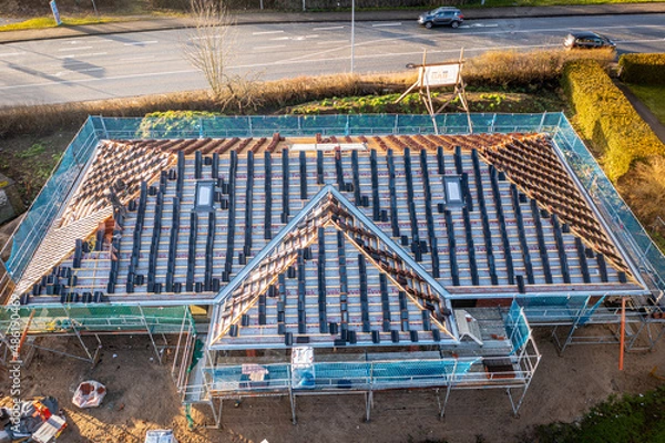 Obraz on the newly built house is in the process of covering the roof with tiles