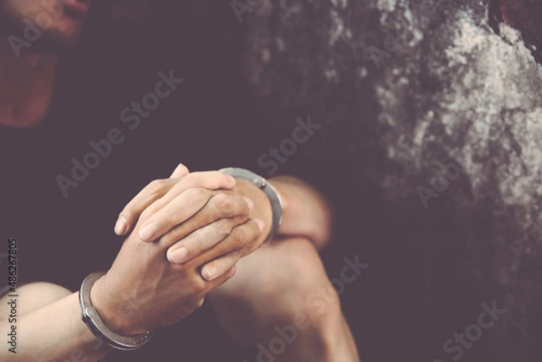 Obraz criminal tying hands with handcuffs.