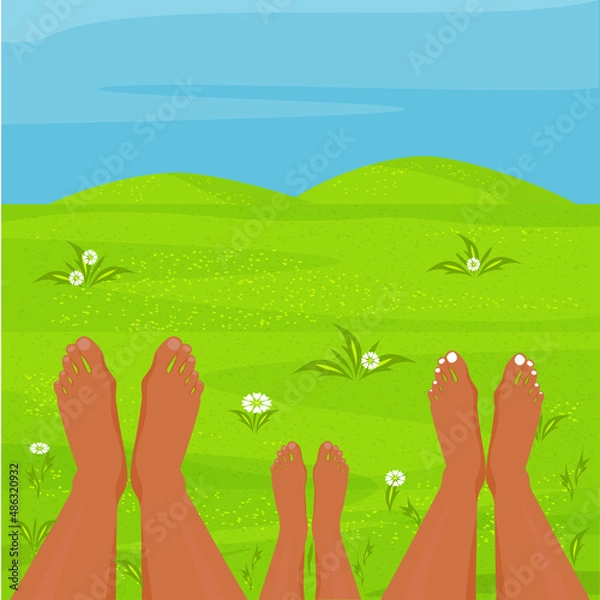Fototapeta A happy family is resting in a meadow. Parents and child are lying barefoot on the grass.