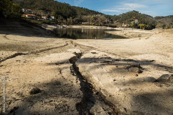 Fototapeta Dry soil and very low water reservoir level in Ermal, north of Portugal due to drought in this time of the year - February 2022. Normally this part of the reservoir is usually full of water
