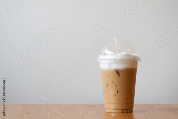 Obraz ice cappuccino in plastic cup on wooden table.  Copy space with white background.