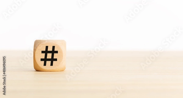 Fototapeta Hashtag symbol on wooden cube. Copy space