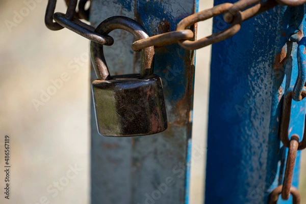 Fototapeta Old rusty padlock and chain on metal door. Old locked gate with chains.