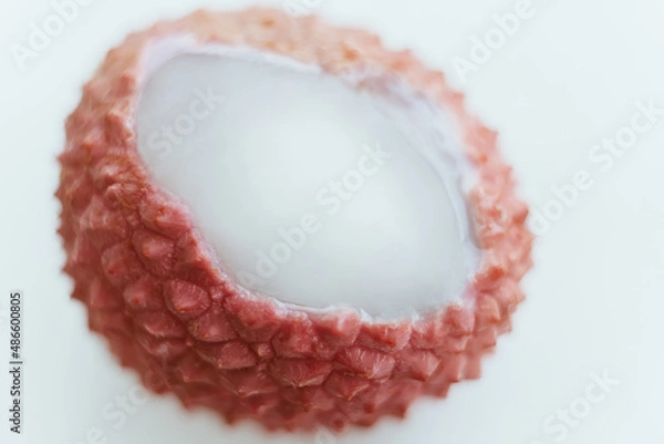 Fototapeta Lychee pink fruit with open shell and white pulp macro close up