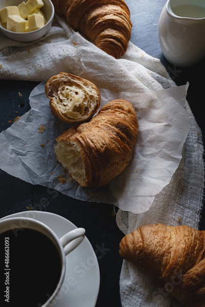 Fototapeta Close up shot of breakfast meal of fresh croissants and coffee. Shot from above, flat lay style. Dark and moody style food image set against a dark background. 