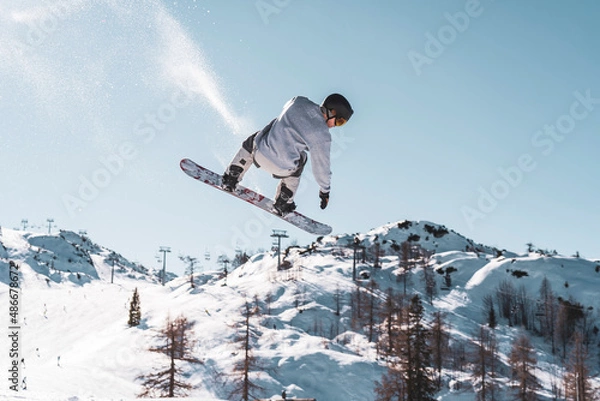 Fototapeta snowboarder jumping in the mountains