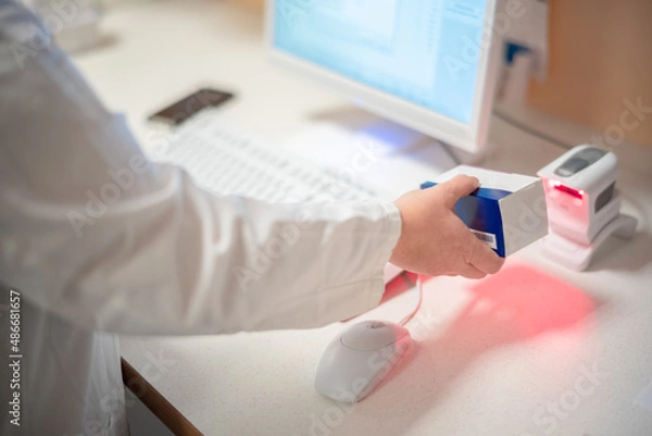 Fototapeta Apothekerin scannt ein Medikament