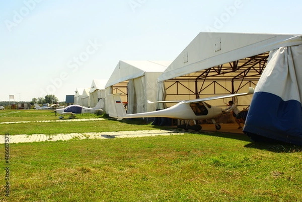 Obraz White Airplane White hangar Grass Green