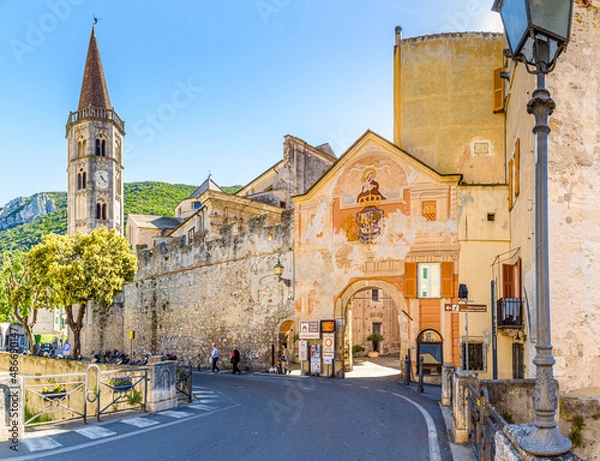 Obraz Finalborgo, Finale Ligure, Italy. May 5, 2021. View of the external facade of Porta Reale and of the ancient walls with the bell tower of the Church of San Biagio on the left.