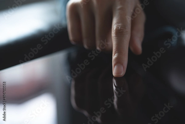 Fototapeta Close up of woman finger touching on digital tablet screen with reflection, business and technology concept