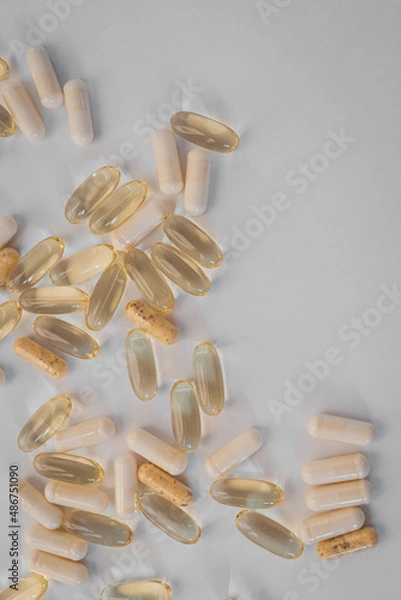 Fototapeta Vitamins and dietary supplements close-up. Macrophoto of capsules. Vitamins on the table.