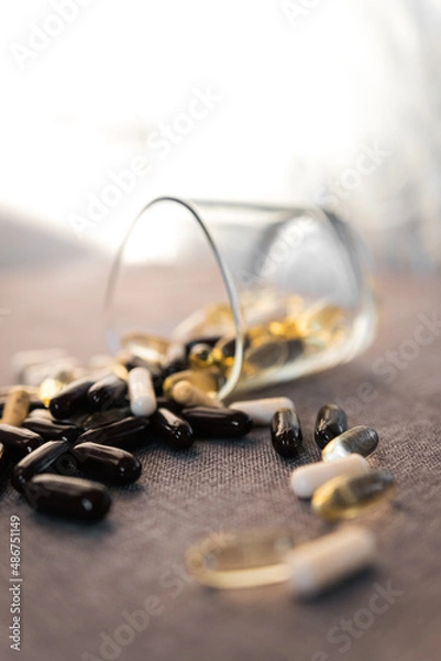 Fototapeta Vitamins and dietary supplements close-up. Macrophoto of capsules. Vitamins on the table.