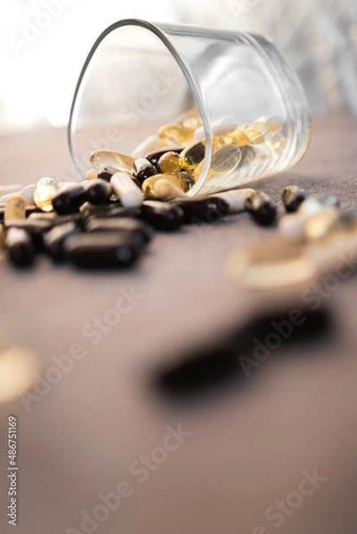 Fototapeta Vitamins and dietary supplements close-up. Macrophoto of capsules. Vitamins on the table.