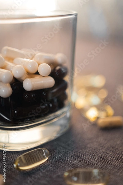 Fototapeta Vitamins and dietary supplements close-up. Macrophoto of capsules. Vitamins on the table.