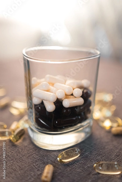 Fototapeta Vitamins and dietary supplements close-up. Macrophoto of capsules. Vitamins on the table.