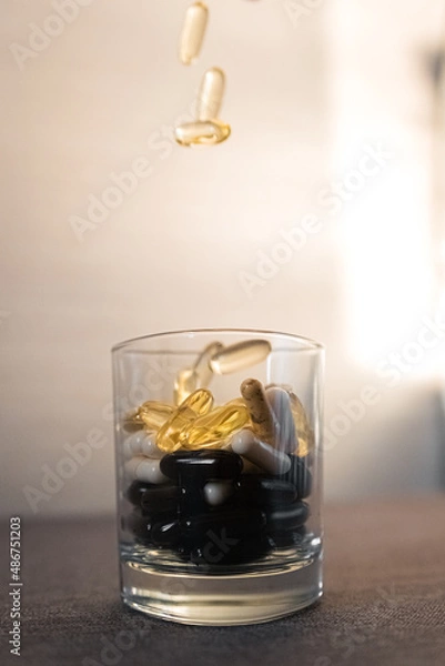 Fototapeta Vitamins and dietary supplements close-up. Macrophoto of capsules. Vitamins on the table.