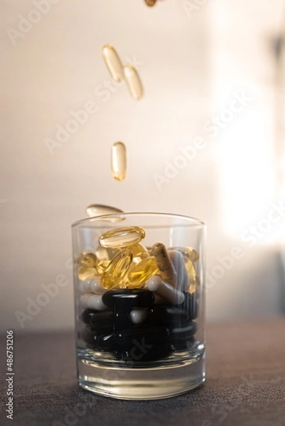 Fototapeta Vitamins and dietary supplements close-up. Macrophoto of capsules. Vitamins on the table.