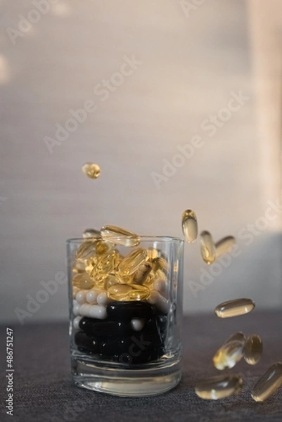 Fototapeta Vitamins and dietary supplements close-up. Macrophoto of capsules. Vitamins on the table.