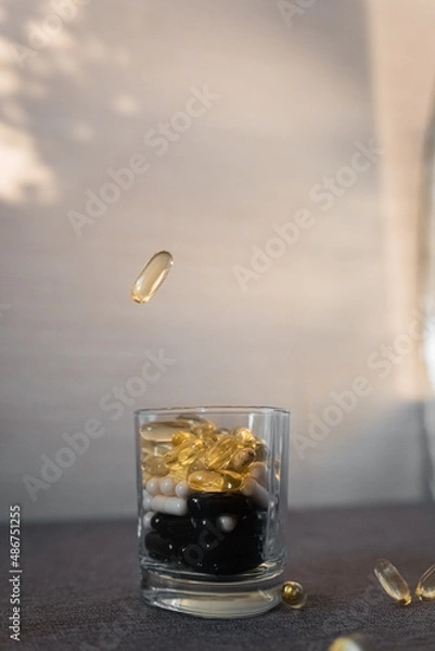 Fototapeta Vitamins and dietary supplements close-up. Macrophoto of capsules. Vitamins on the table.